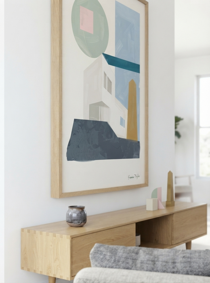 A framed  Mid-Century Minimalist Print featuring a Bauhaus Geometric House Poster designed to complement modern, Scandinavian and Japandi interiors by Phylae Posters. hangs above a light wood console table in a bright, modern room. The artwork features abstract shapes in muted blue, gray, white, beige, and soft pink, enclosed in a light natural wood frame.