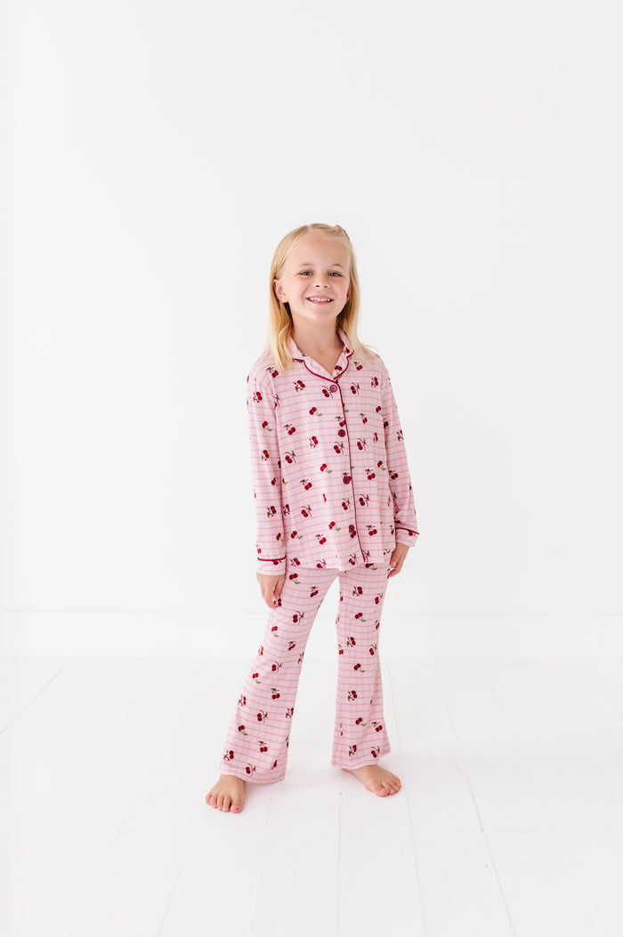 Young girl wearing pink pajamas with a pattern on a white background