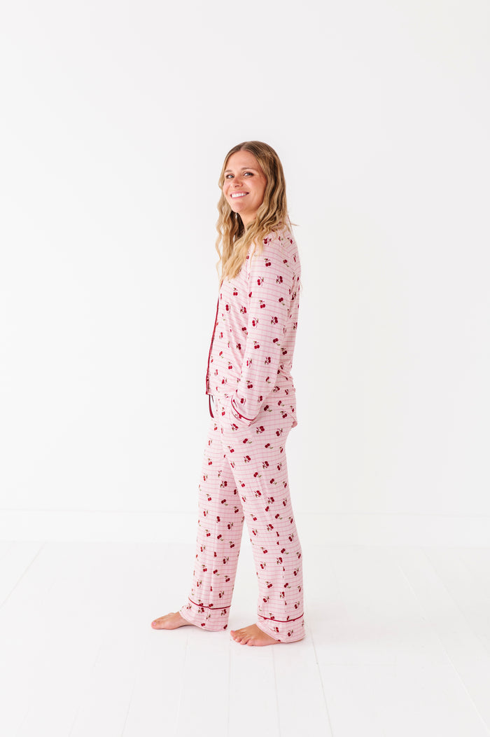 Woman wearing pink pajamas with a cherry pattern on a white background