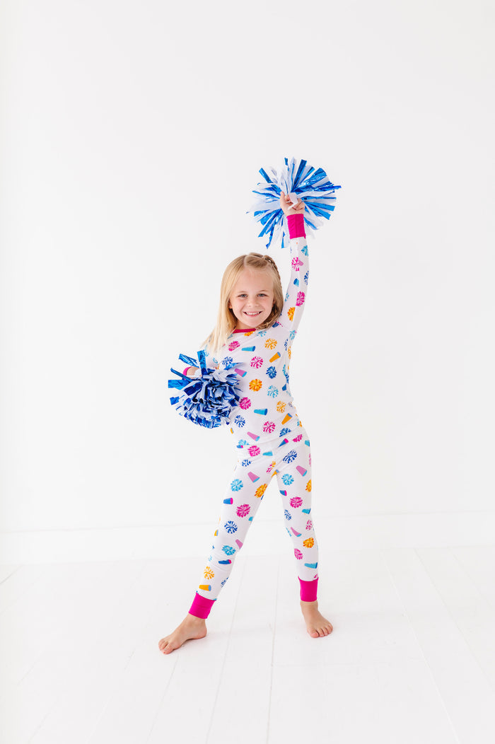 Child wearing a colorful pajamaa with pom-poms on a white background