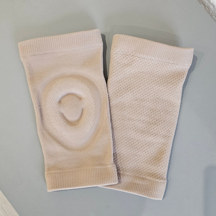 Pair of beige knee pads on a light gray surface
