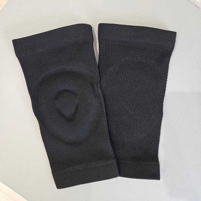 Pair of black knee-high socks on a light gray background